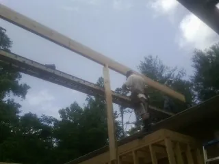 Carpenter setting a ridge beam over a new addition frame — Ice Dam Removal by Roofing Brothers in South Haven