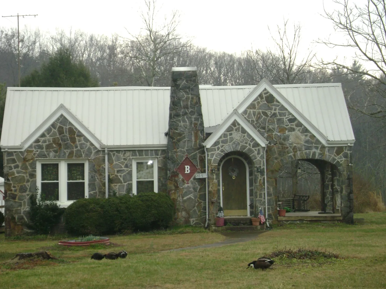 White metal roof on a stone cottage with steep gables in South Haven