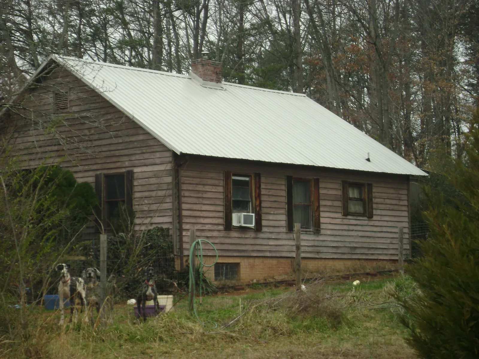 White metal roof on an old wood sided farmhouse, from a Metal Roof Installation job in South Haven